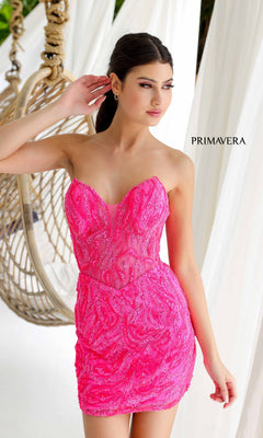 A woman poses in front of a hanging chair wearing the Short Homecoming Dress 4222 by Primavera, a bright pink strapless dress with sparkling sequins, with "PRIMAVERA" text in the background.