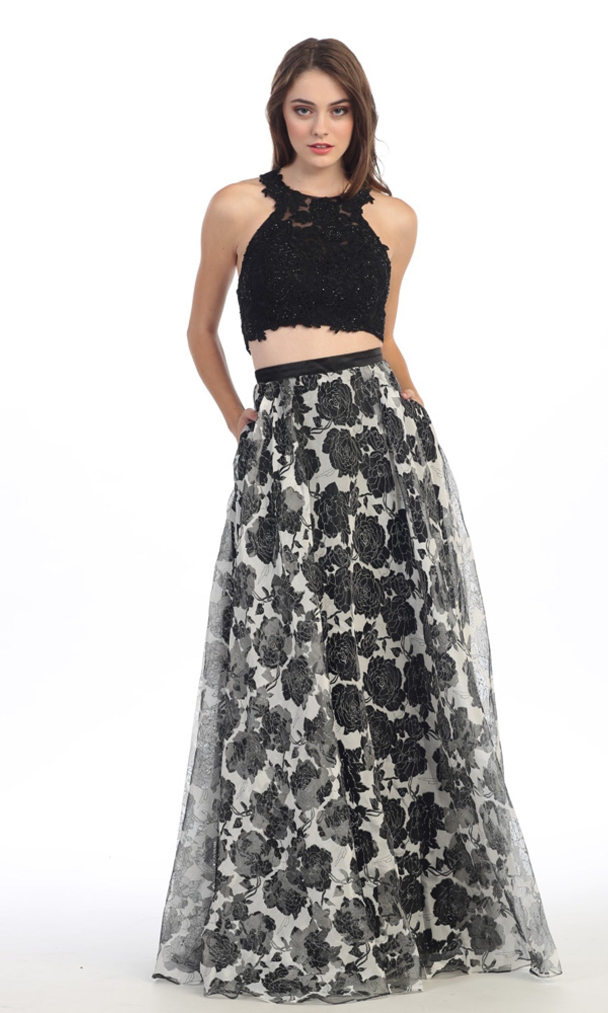 A woman poses against a white background wearing the Eureka 4222 long formal dress, featuring a black lace crop top and a high-waisted, floral chiffon skirt.