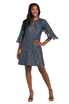 Woman modeling the R&M Richards 4226 Short Lace Semi-Formal Dress, knee-length with flared sleeves, a small front keyhole, and an elegant A-line silhouette. She stands smiling with one hand on her hip.