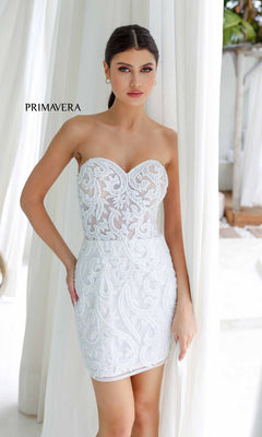 A woman models the Strapless Beaded Short Hoco Dress: Primavera 4227 indoors before white curtains, with "Primavera" displayed on the left side.