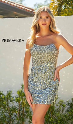 A woman in the Strapless Fringe Hoco Dress: Primavera 4229 with a sequin-print bodice stands outdoors in sunlight, greenery, and a white wall behind her. "PRIMAVERA" appears on the left.