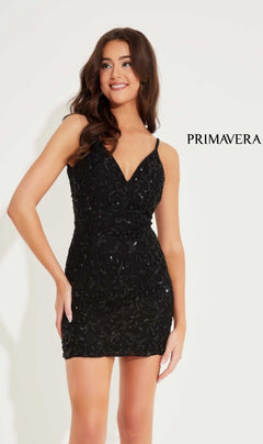A woman models the Short Homecoming Dress 4230 by Primavera, a sleeveless black sequin-beaded mini dress, standing against a white background with the "PRIMAVERA" text on the right.