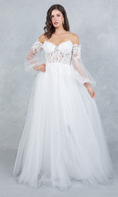 A woman stands against a light gray textured background wearing the Cinderella Couture 4234 long formal dress, featuring a white, off-the-shoulder design with a lace applique corset bodice and sheer tulle sleeves.