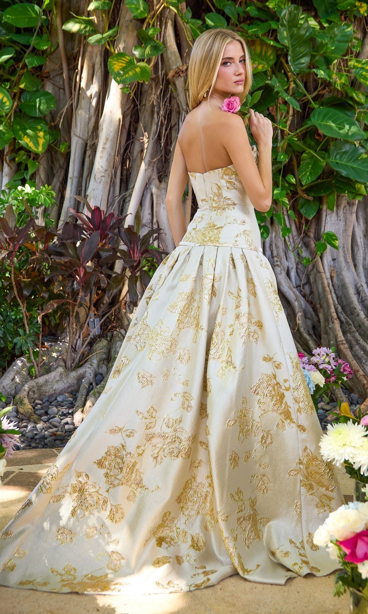 Ava Presley 42460 cream floor-length ball gown with a metallic gold floral pattern, featuring a fitted bodice and a full, pleated skirt.