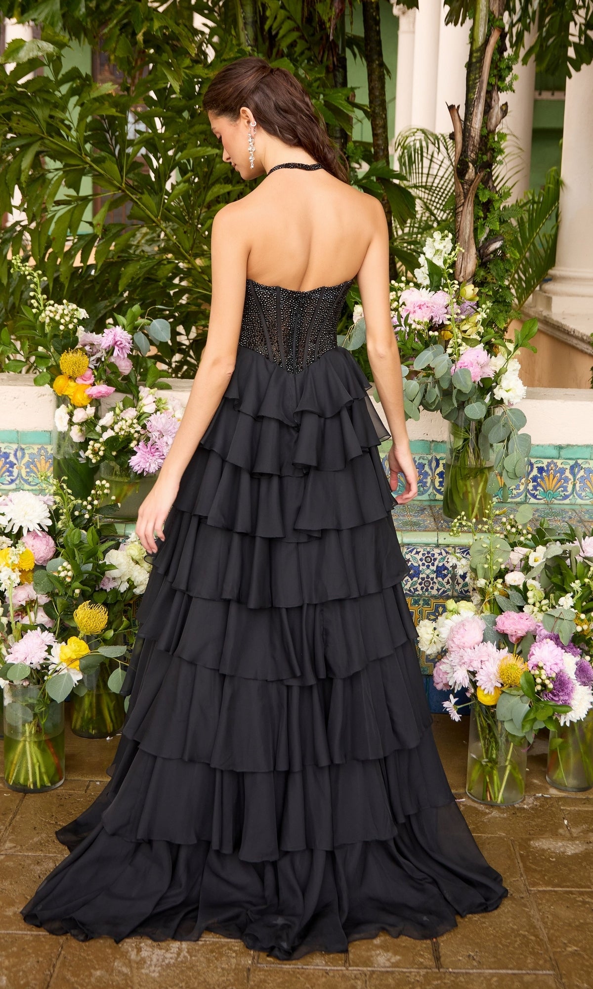 Back view of the Ava Presley 42472 long prom dress, a strapless black corset style with a beaded bodice and a floor-length, tiered ruffled skirt.