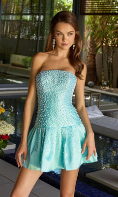 A woman in the Ava Presley 42505 short strapless homecoming dress in light blue stands indoors by a modern pool, her hand on a ledge. The fit and flare dress features delicate beading for an elegant touch.