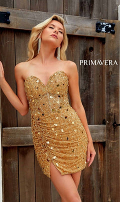 A woman stands before wooden doors in the Beaded Strapless Short Hoco Dress: Primavera 4252, featuring a strapless, beaded design and sweetheart neckline; "PRIMAVERA" is displayed beside her.