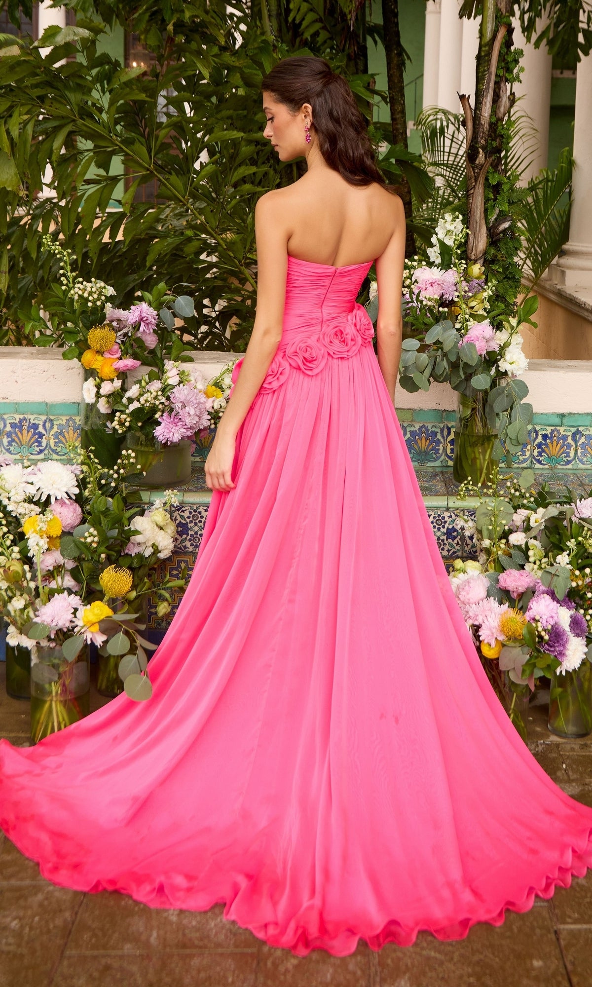 Back view of the hot pink, strapless, floor-length Ava Presley 42536 gown featuring rosette detailing at the waist.