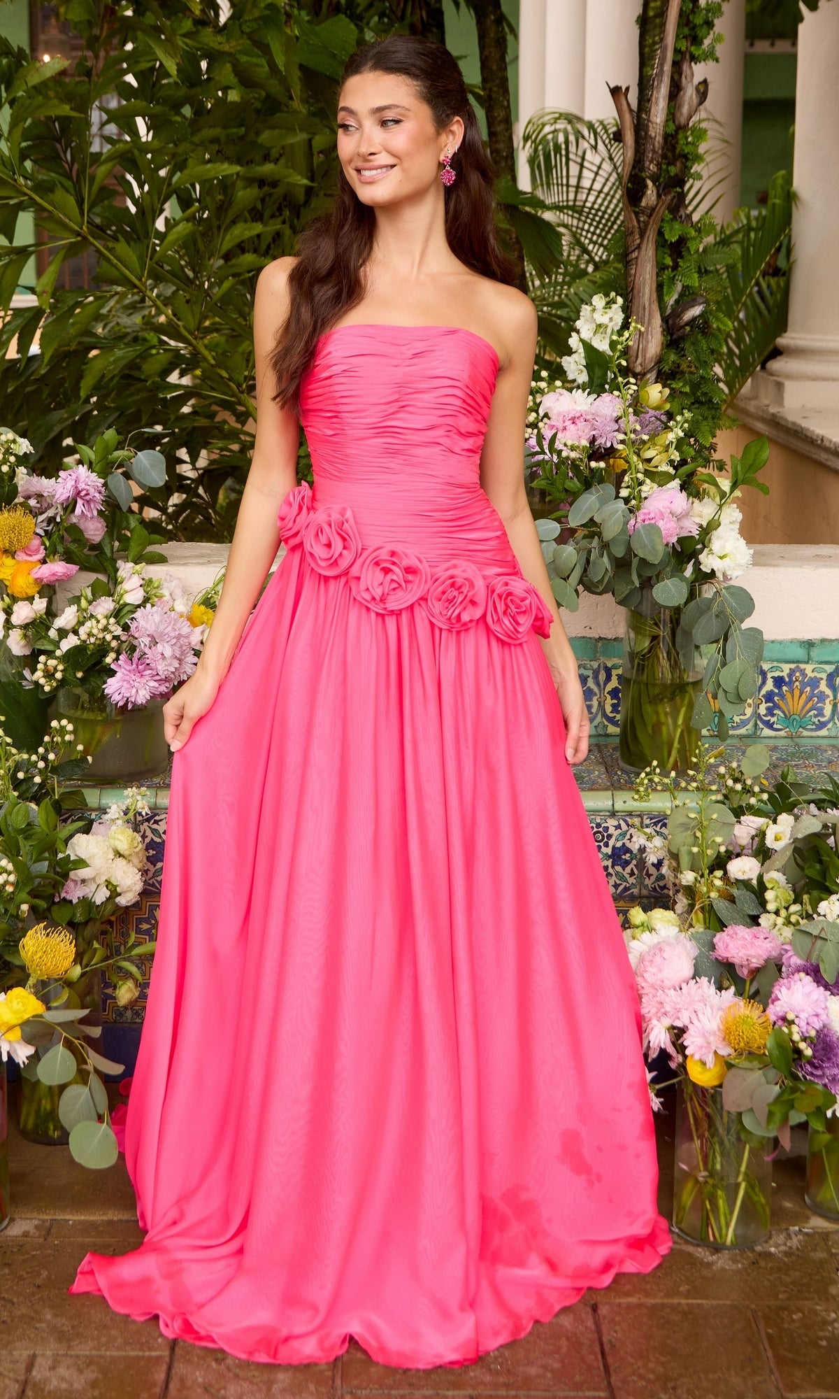 Ava Presley 42536 hot pink strapless floor-length gown featuring a ruched bodice and a row of fabric rosettes at the waist.
