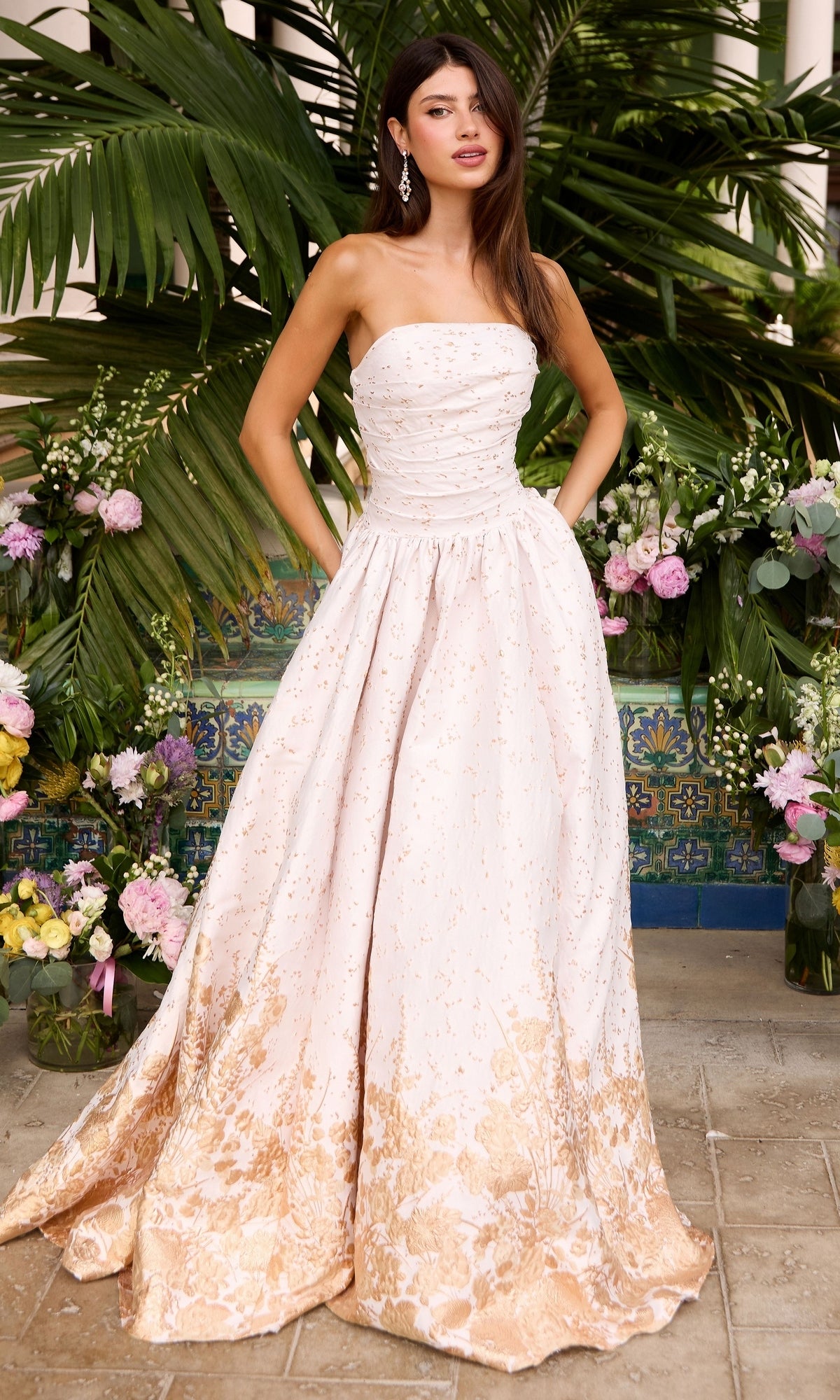 Ava Presley 42540 strapless ivory floor-length prom ball gown with a gold floral pattern at the hem.