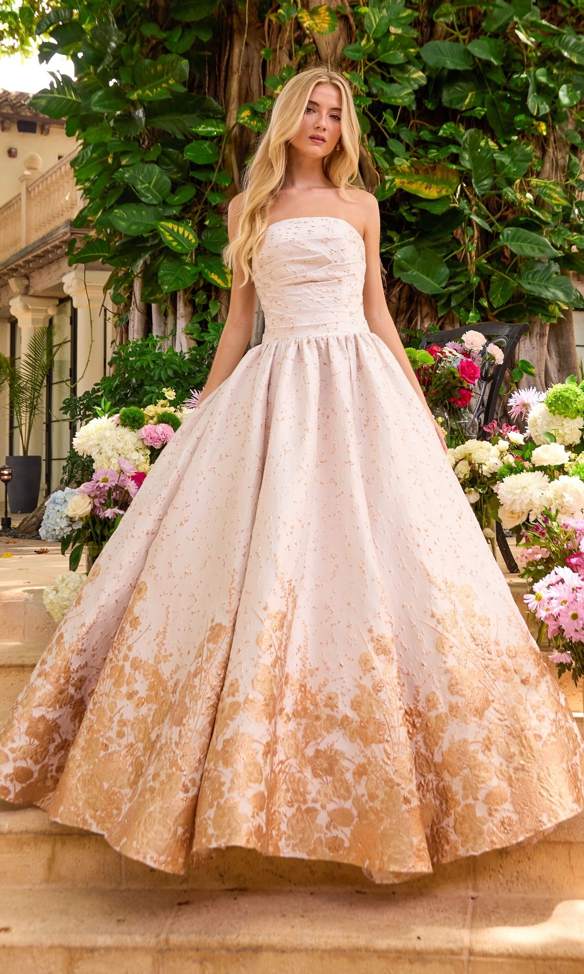 A strapless Ava Presley 42540 ball gown featuring a fitted bodice and a full skirt with a gold floral pattern at the hem.