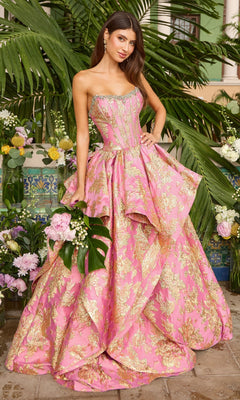 A woman wears a strapless pink and gold Ava Presley 42541 brocade gown with a corset bodice and a full skirt, holding a bouquet of flowers.