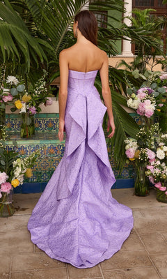 Back view of a Long Prom Dress: Ava Presley 42552, a strapless lavender floor-length mermaid gown featuring a textured bodice and a tiered, flowing train.