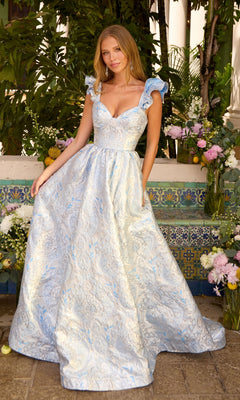 A woman wearing an Ava Presley 42557 long prom dress in pale blue and silver metallic brocade with ruffled straps and a full, floor-length A-line skirt.