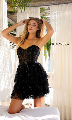 A woman poses indoors near white curtains with "PRIMAVERA" in the background, wearing the Short Homecoming Dress 4263 by Primavera—a black, strapless sweetheart dress.