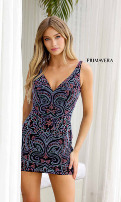 A woman indoors wears the Multicolor Short Beaded Hoco Dress: Primavera 4271—sleeveless, patterned with pink and blue beads. "PRIMAVERA" is displayed on the curtain behind her.
