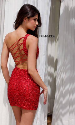A woman wears the Cut-Out Short Sequin Hoco Dress: Primavera 4293, its red sequins sparkling under the light as she stands in front of white curtains, showing off the lace-up back detail.