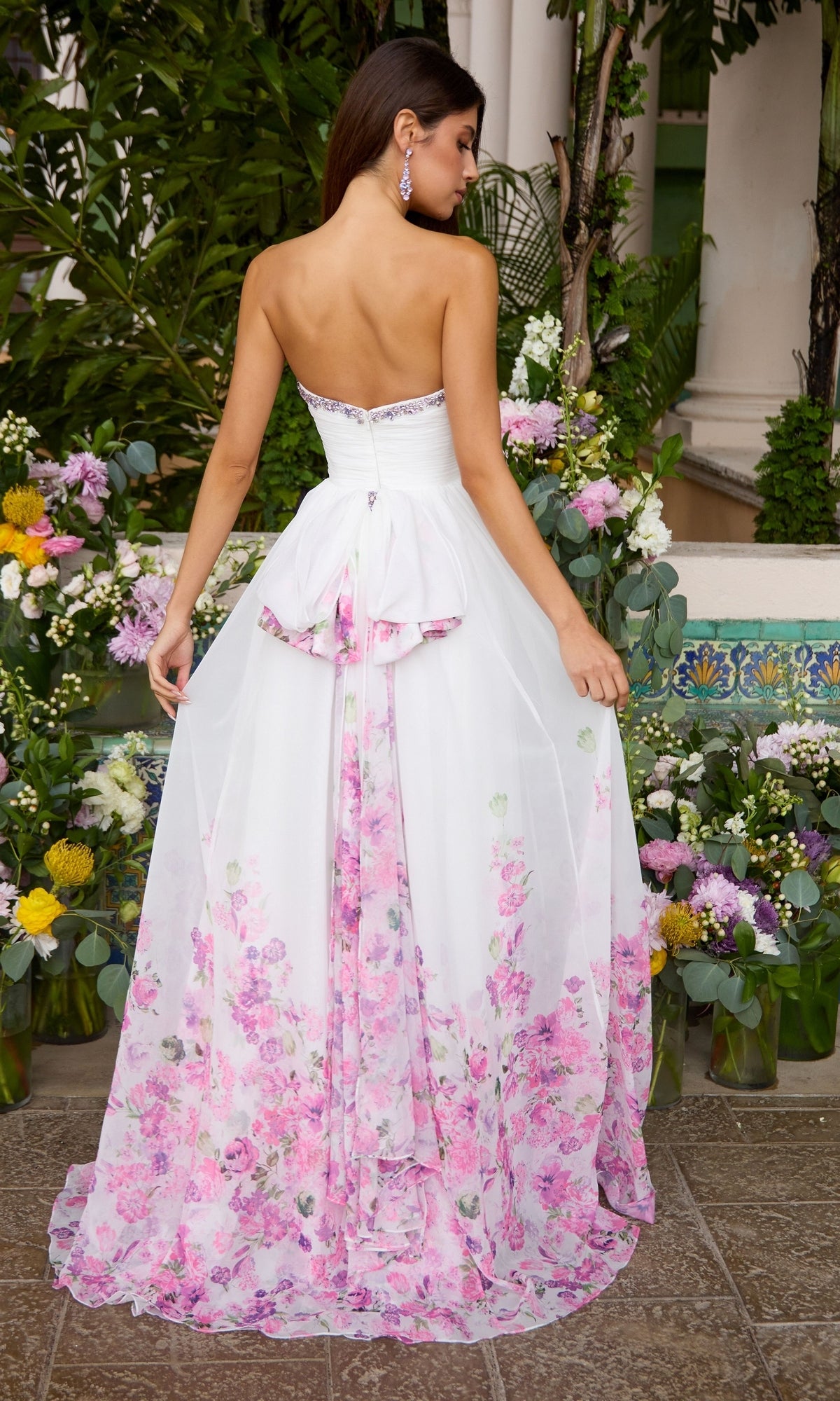 Ava Presley 43001 strapless white floor-length A-line prom dress with a pink floral print on the skirt and a bustle detail at the back.