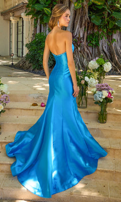 A woman in a beaded, strapless, floor-length bright blue mermaid gown with a train stands on outdoor stone steps, wearing the Long Prom Dress: Ava Presley 43014.