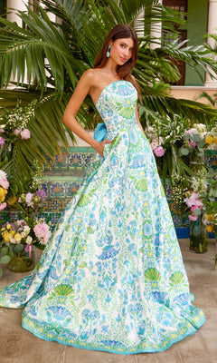 A woman wearing an Ava Presley 43017 strapless, floor-length white prom ball gown featuring a blue and green botanical print and a solid blue bow at the back.