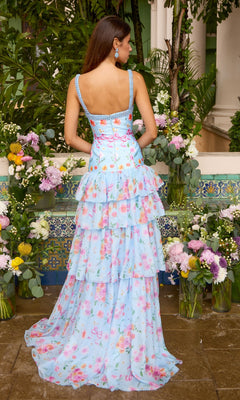 Back view of the Long Prom Dress: Ava Presley 43035, a light blue floral ruffled gown with a square neckline, tiered layers, pink ribbon details, and beaded trim, surrounded by vases of flowers.