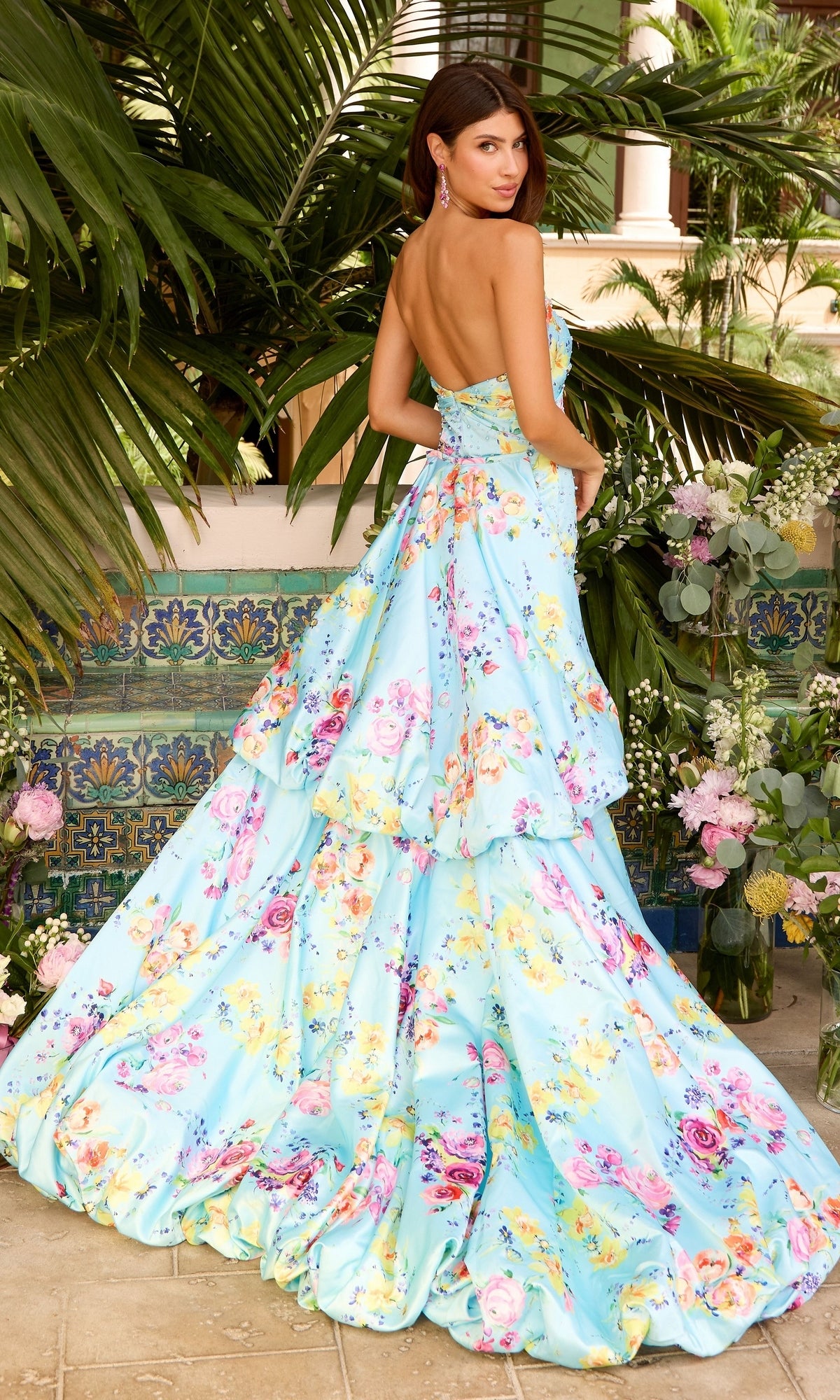 A woman wearing a light blue, floor-length ruffled strapless floral Long Prom Dress: Ava Presley 43039.