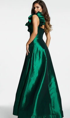 A woman wearing the Long Formal Dress: Jovani 43048, a shiny emerald green satin evening gown featuring ruffle shoulder detail, stands against a plain background and looks over her left shoulder.