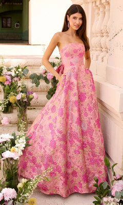 A woman wearing an Ava Presley 43082 strapless, floor-length hot pink multi prom ball gown with a gold floral pattern and pockets, standing on stone steps surrounded by flower arrangements.
