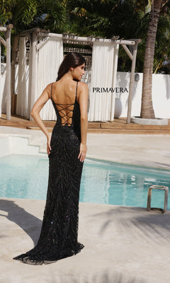 A woman in the Primavera 4310 Scoop-Neck Long Beaded Prom Dress stands by a pool, facing away, with lush greenery and white outdoor curtains forming an elegant backdrop.