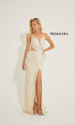 A woman in the Primavera 4327 long prom dress—shimmering, sleeveless, beige with sequined cutout waist, thigh-high slit, and open back—stands before a plain background featuring "PRIMAVERA.