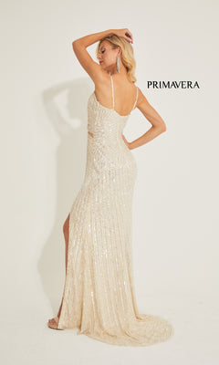 A woman models the Primavera 4327 long prom dress, featuring sequins, a high slit, and open back, against a plain background with "PRIMAVERA" beside her.