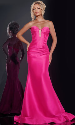 A woman poses in the Sheer-Back Strapless Prom Gown Jovani 43350 in fuchsia, its corset-style bodice and mermaid silhouette accentuating her figure as her reflection shimmers against a dark backdrop, emphasizing the gown’s structured elegance.