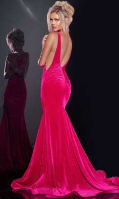 A woman stands facing away in a bright pink, backless, sleeveless Long Prom Dress: Jovani 43578, her reflection visible in the mirror beside her.