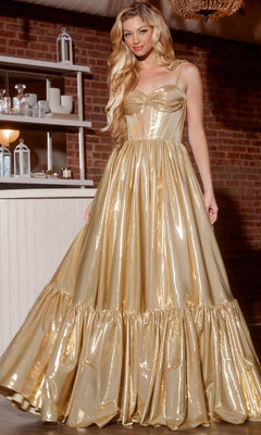 A woman wearing the Jovani 43596 Long Prom Dress, featuring a shiny gold color with a fitted corset bodice and full ruffled skirt, stands indoors near shelves and brick walls.