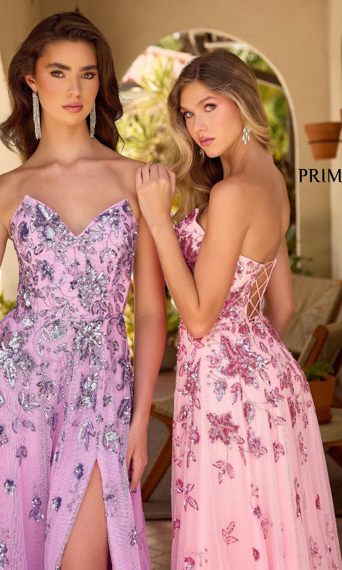 Two women stand outdoors in Primavera 4361 Strapless Beaded Long Prom Dresses—one pink, one lilac—with silver floral patterns, radiating elegance.