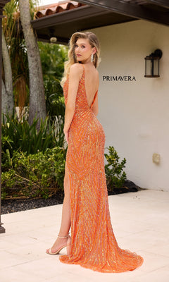 A woman in the Long Prom Dress: Primavera 4368 stands on a patio, looking over her shoulder, with "PRIMAVERA" displayed on the wall behind her.