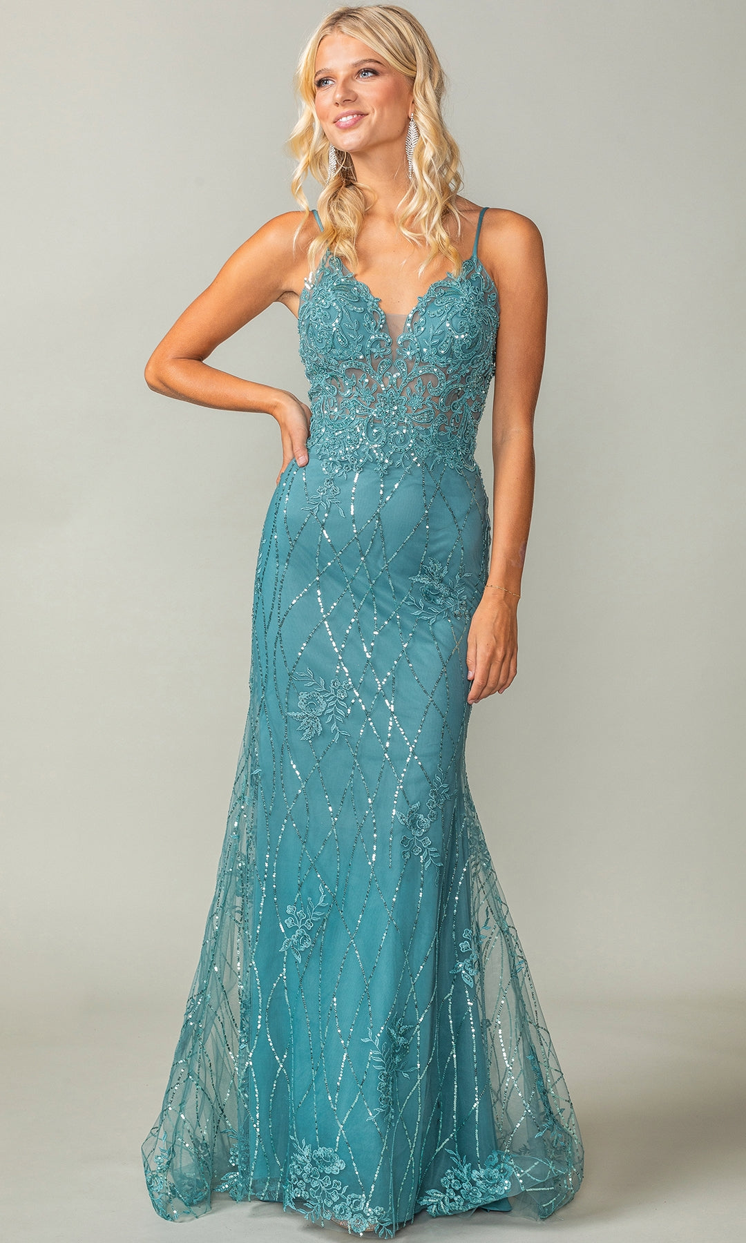 A woman wears the Sequin-Print Long Prom Dress: Dancing Queen 4371—a teal, floor-length gown with thin straps, floral lace details, and silver sequin accents—standing against a plain light gray background.