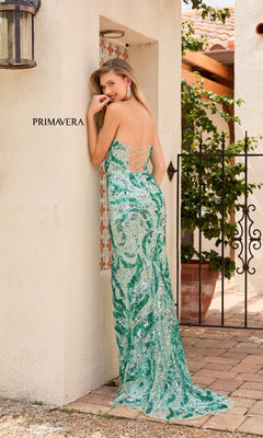 A woman in a Primavera 4373 Strapless Long Sequin Prom Dress leans against a wall.