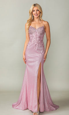 A woman stands against a plain background wearing the Long Glitter Prom Dress: Dancing Queen 4375—shimmering light pink with thin straps, sequin bodice, high side slit—paired with silver open-toe heels.