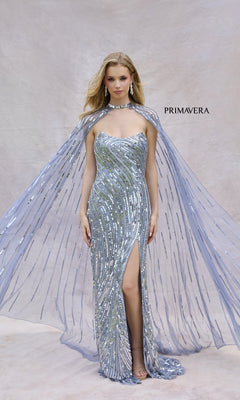 A woman poses in the Primavera 4376 long prom dress, featuring sequins, a high slit, and a matching sheer cape, set against a plain light backdrop with "PRIMAVERA" displayed on the right.