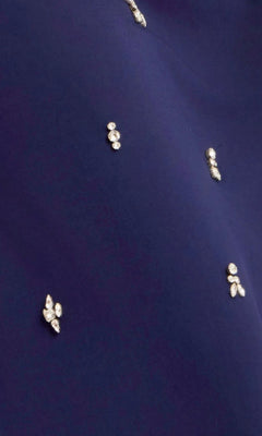 Close-up of the dark blue fabric from the Jovani 43824 Long Prom Dress, adorned with small clusters of white or silver beads and crystal-beaded appliques sewn in a scattered pattern.