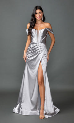A woman models the Dancing Queen 4382 off-shoulder long prom dress in silver, featuring a corset bodice, ruched details, and a thigh-high slit, as she stands against a plain gray backdrop.