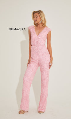 A woman stands against a plain background wearing the Primavera 4384 long prom jumpsuit, featuring light pink textured sequins, a V-neckline, and straight leg pants. "PRIMAVERA" appears to her left.