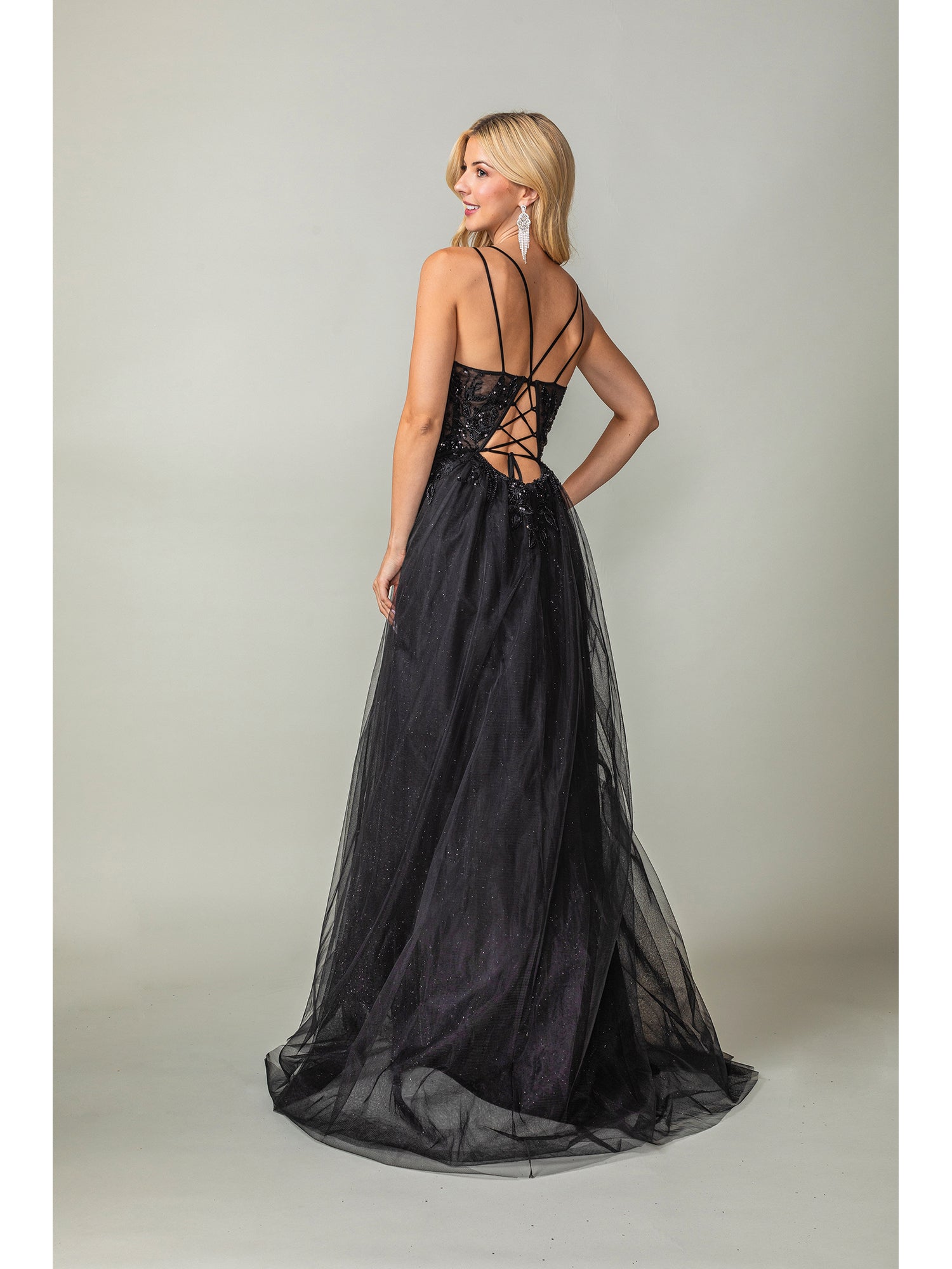 A woman faces away from the camera against a plain background, wearing the Long Prom Dress 4393 by Dancing Queen—a black, tulle a-line formal dress with a lace-up back.