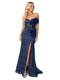 A woman stands against a white background wearing the Side-Bow Strapless Long Glitter Prom Dress 4394, a navy blue, floor-length gown featuring a thigh-high slit, sequin details, and a decorative bow.