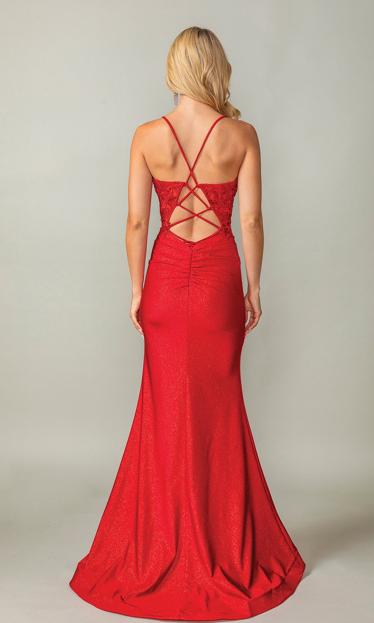 A woman faces away in the Strappy-Back Long Prom Dress: Dancing Queen 4396, a red fitted evening gown with thin straps and a crisscross lace-up open back.