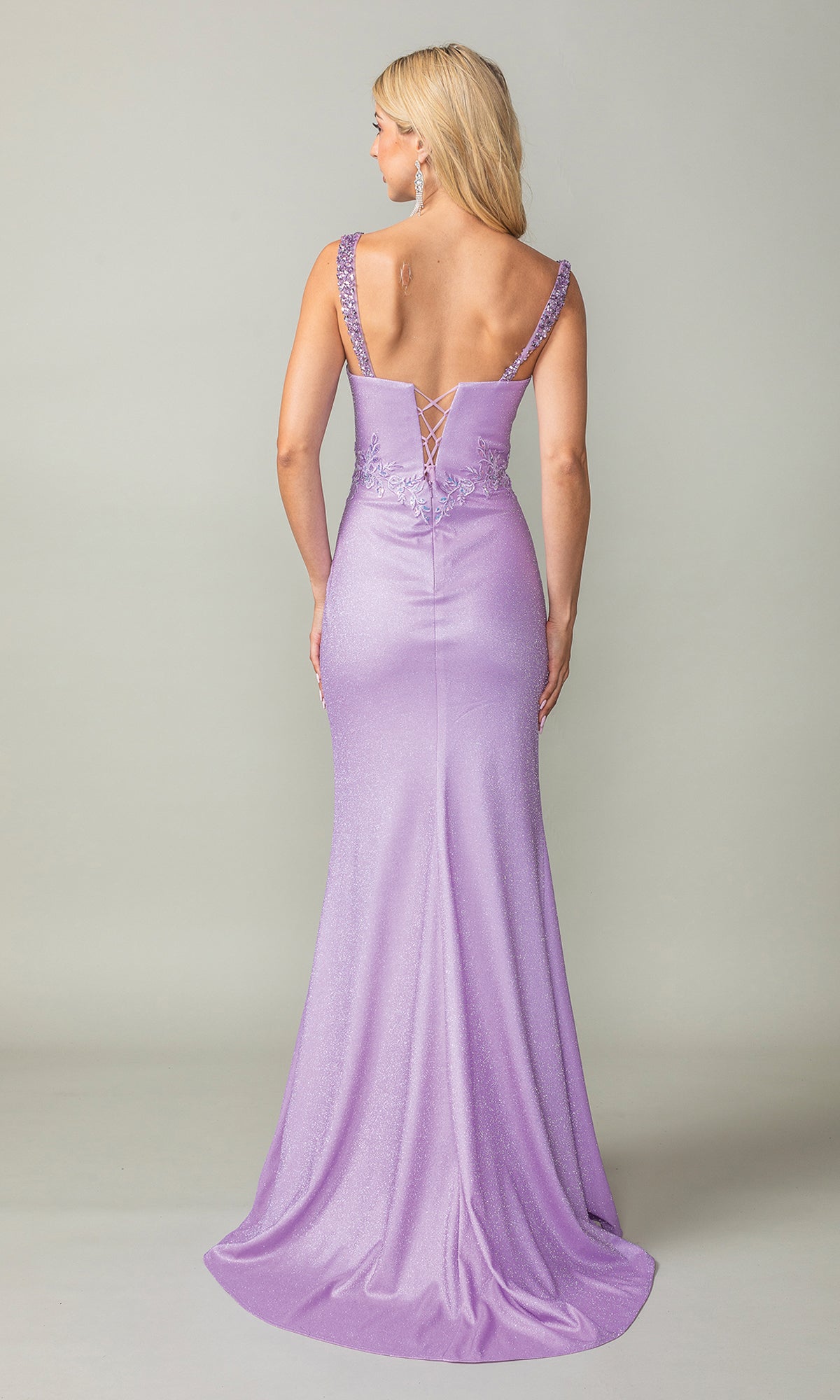 A woman in the Embellished Sheer-Corset Long Prom Dress 4400, a fitted, floor-length lavender gown with an embellished corset and lace-up back, stands facing away against a plain background.