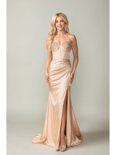 A woman in the Off-the-Shoulder Long Prom Dress 4401 with beaded details, a corset bodice, and thigh-high slit pairs the champagne gown with silver heels against a plain background.