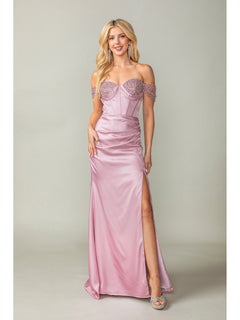 A woman wears the Off-the-Shoulder Long Prom Dress 4401 with beads, featuring a light pink hue, beaded straps, corset bodice, thigh-high slit, and silver heels against a plain background.