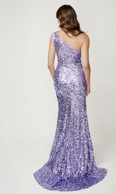 A woman with wavy brown hair models the Sequin Prom Dress: Nina Canacci 4405, featuring a one-shoulder neckline and floor-length purple sequins, shown from the back against a plain light background.